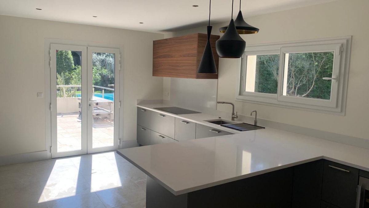 Modern Biot kitchen renovation with white countertops and wood accents