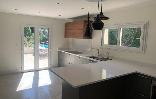 Modern Biot kitchen renovation with white countertops and wood accents