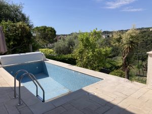 Cracked stone coping and sunken terrace corner beside pool.