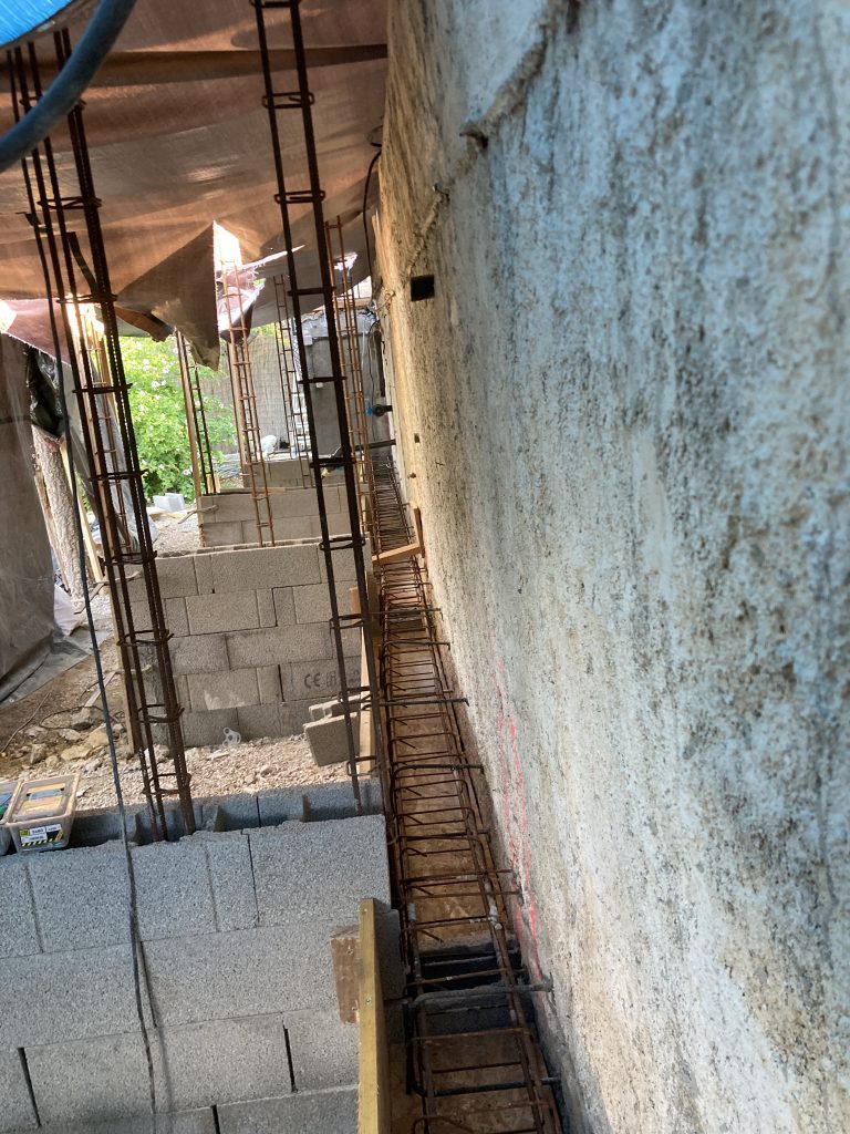 Reinforcement work in progress beside swimming pool.